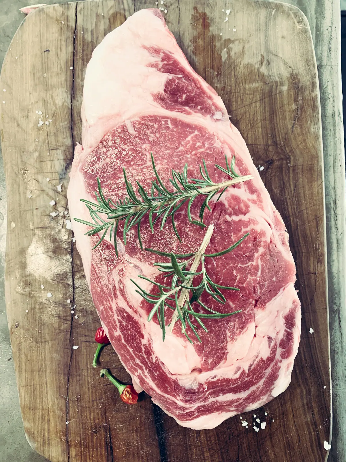 Rohes, marmoriertes Ribeye-Steak mit Rosmarin